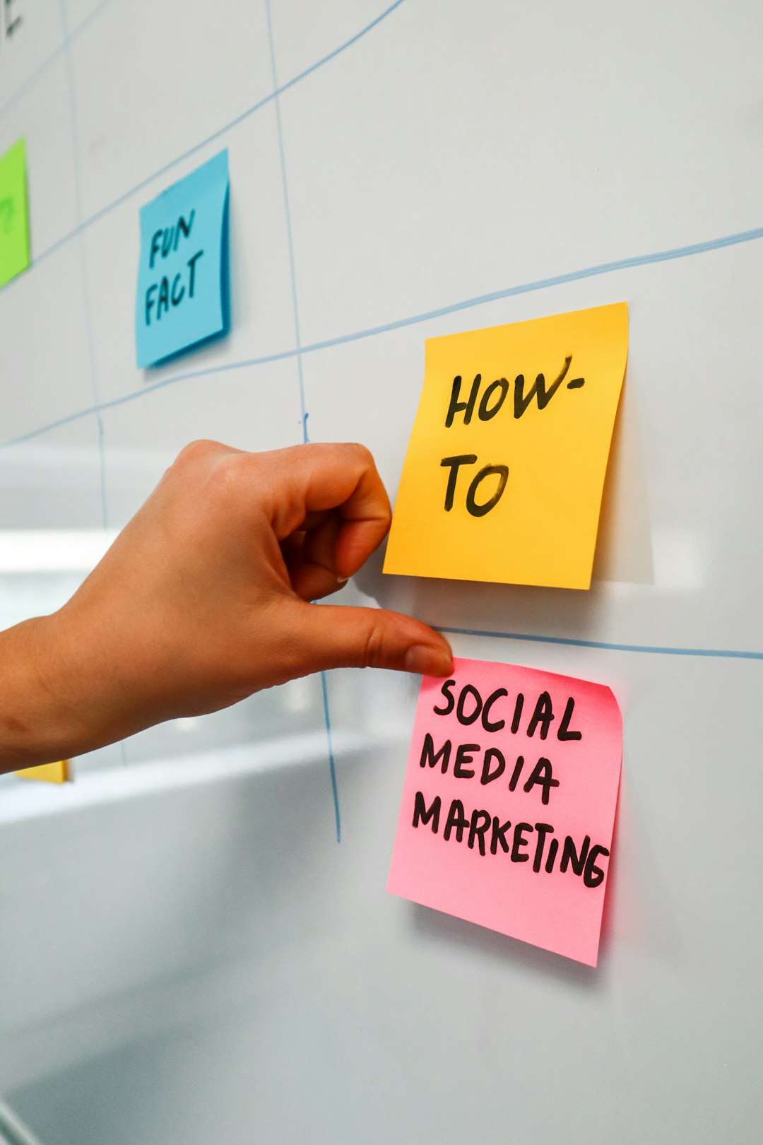 services-02 Person sticking a post-it on a white board with the words Social Media Marketing written on it